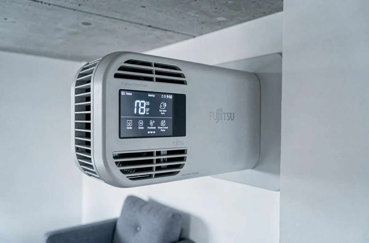 Gros plan sur l'écran de contrôle d'une pompe à chaleur Fujitsu murale dans un appartement moderne