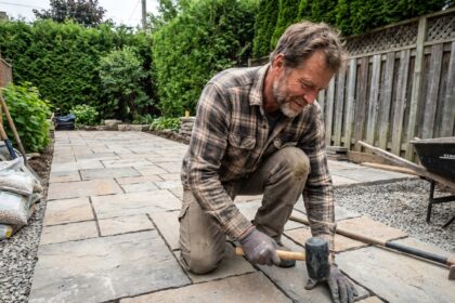 Homme en travail manuel pose une terrasse en pierre